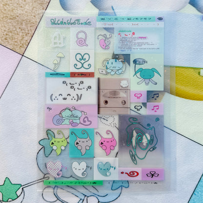 A clear plastic sleeve containing a sheet of pastel decorative stickers with cute cartoon motifs, placed on a patterned surface.